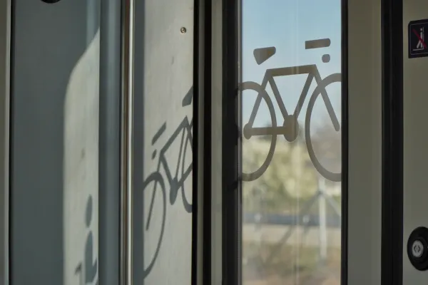 Símbolo de una bicicleta en la puerta de vidrio de un tren en Belgrado, Serbia, que indica transporte de bicicletas.