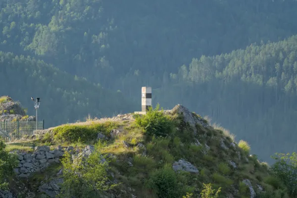 A striking black and white pillar stands on a rocky outcrop at Lazic Dam on Zaovine Lake, Serbia.