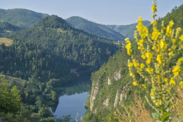 Lac Spajići, Serbie, entouré de falaises et de prairies de montagne vertes.