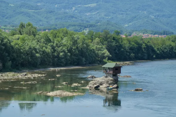Das "Haus an der Drina" thront auf einem Felsen im Fluss Drina in Serbien, umgeben von einer üppigen Naturlandschaft.