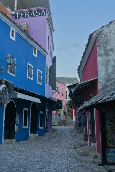 Rue de la vieille ville de Mostar tôt le matin avec des maisons colorées et des pavés.