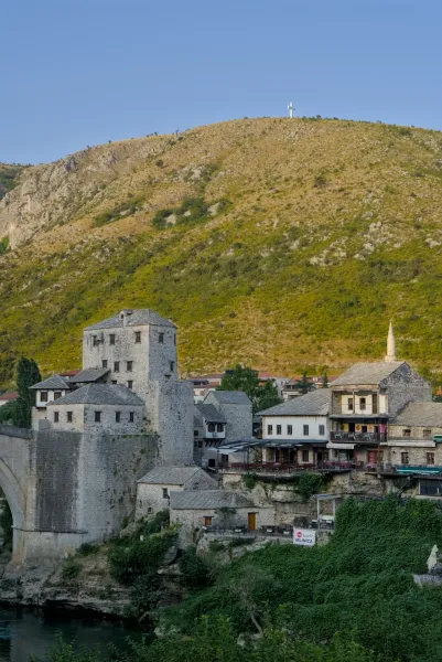 Heure dorée sur la vieille ville historique de Mostar avec des bâtiments en pierre et une montagne en arrière-plan.