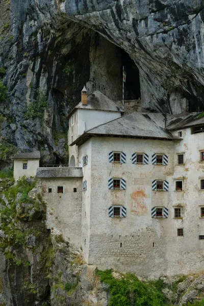 Antico Castello di Predjama in una parete rocciosa, un antico castello costruito nella roccia in Slovenia, con architettura visibile e pietra naturale.