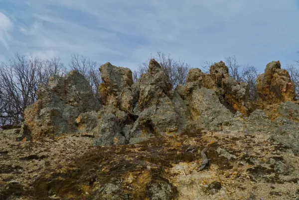 Orlovo Stijene (Roches de l'Aigle) à Fruška Gora, Serbie, avec des formations rocheuses dramatiques et des arbres dénudés en arrière-plan.