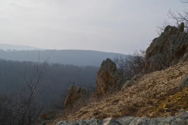 Die "Orlove Stene" auf Fruska Gora, Serbien, mit felsigem Gelände und bewaldeten Hügeln im Hintergrund.