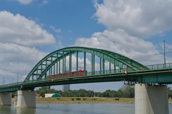 Le Vieux Pont de Sava à Belgrade avec un tramway rouge le traversant sur fond de ciel bleu.