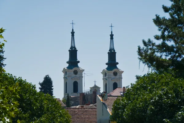 Dva zvonika Crkve Svetog Nikole u Sremskim Karlovcima, Srbija, na pozadini vedrog plavog neba.