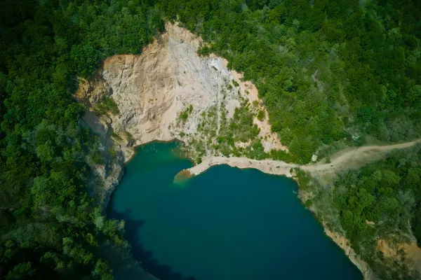 Lac Ledinačko vu à vol d'oiseau, Serbie, avec de l'eau turquoise et des arbres verts.