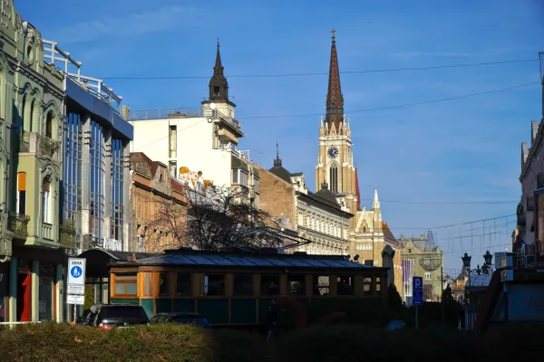 Vista di Piazza della Libertà dalla via Železnička a Novi Sad, Serbia, con un tram e una chiesa.