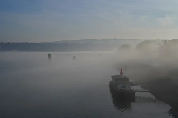 Embarcadero en niebla en el Danubio con vistas a Fruska, adecuado para galería o impresión.