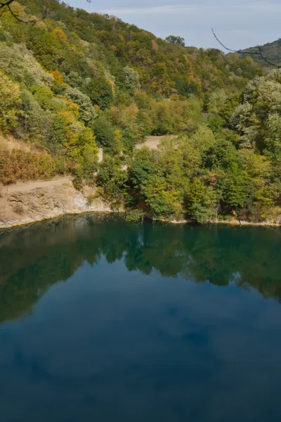 Der Wolkenhimmel spiegelt sich im Ledinačko-See und schafft eine malerische Landschaft.