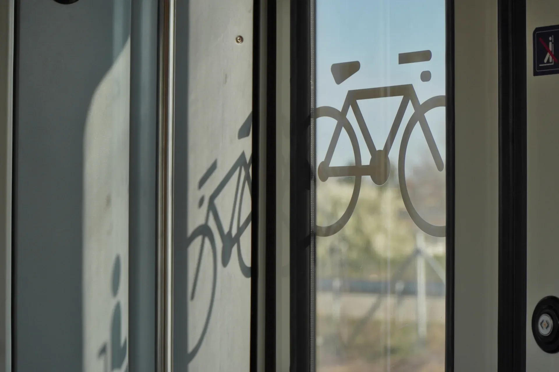Un símbolo de bicicleta en la puerta de vidrio de un tren en Belgrado, Serbia, que indica el transporte de bicicletas.