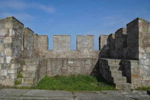 Stone battlements and stairs of Smederevo Fortress with a blue sky in the background.