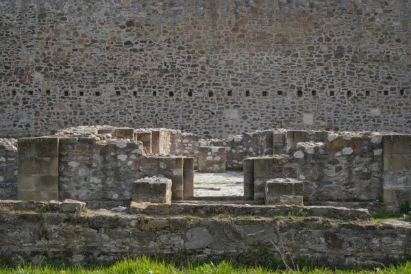 The ruins of Smederevo Fortress, with a large stone wall in the background and collapsed stone walls in the foreground.