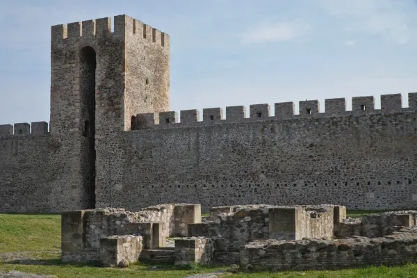 Le rovine di un edificio religioso sono visibili di fronte all'imponente muro di pietra e alla torre di guardia della Fortezza di Smederevo in Serbia.