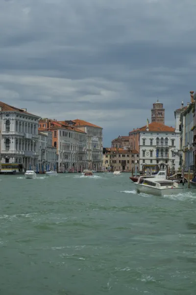Kanale Grande u Veneciji sa istorijskim zgradama i čamcima pod dramatičnim nebom.