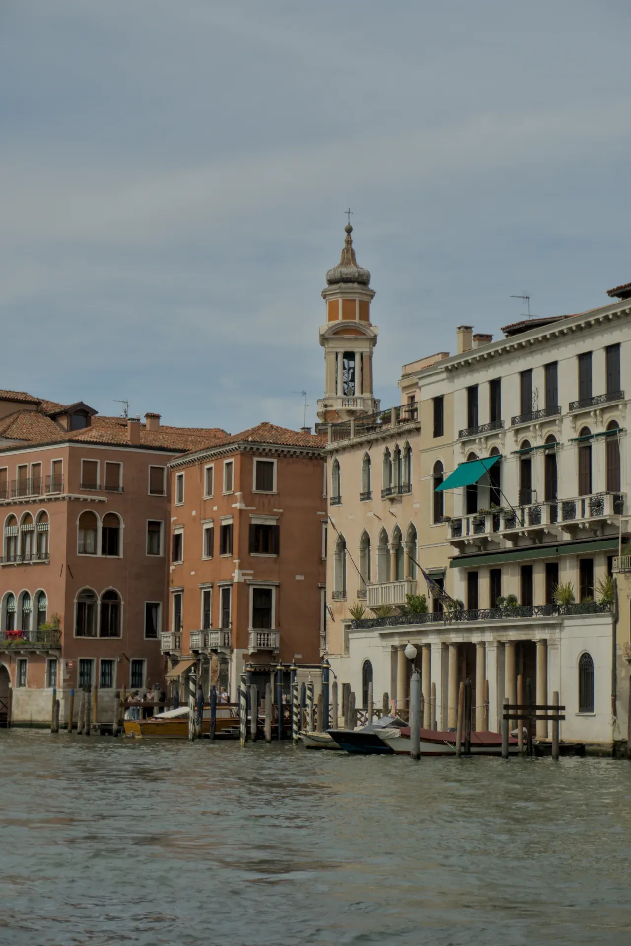 Photographie de bâtiments sur le Grand Canal à Venise, Italie, avec un clocher proéminent et des bateaux dans l'eau.