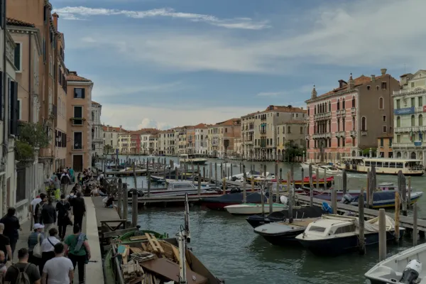 Boote und Gebäude am Canal Grande in Venedig, Italien, unter einem bewölkten Himmel.