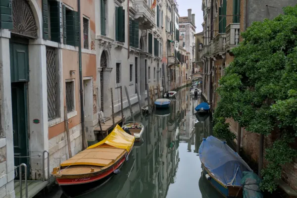 Ein schmaler Kanal in Venedig, gesäumt von historischen Gebäuden und schlafenden Booten, ein ideales Kunstwerk für Innenräume.