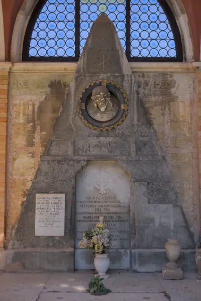 Eterični portret grobnice na groblju San Michele u Veneciji, sa poprsjem i cvetnim aranžmanom.