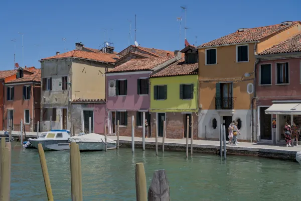 Šarene kuće na kanalu ostrva Murano, Venecija, sa čamcem na doku.