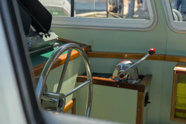 Nahaufnahme des glänzenden Steuerrads eines venezianischen Wasserbusses, bereit zur Fahrt auf den Kanälen.