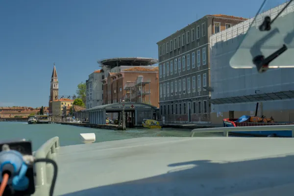 Pogled na venecijanski kanal sa urgentnim centrom, heliodromom i tornjem na pozadini plavog neba.