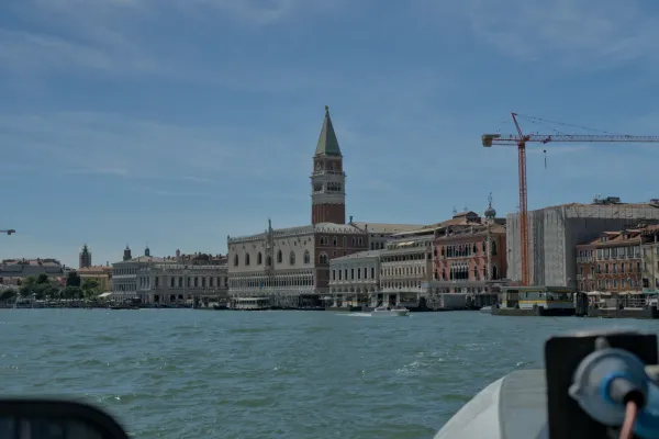 Küste Venedigs mit historischen Palästen und türkisfarbenem Wasser im Sonnenschein.