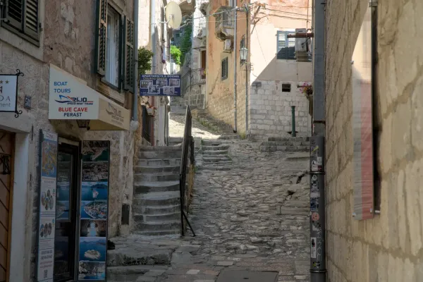 Un ripido vicolo acciottolato a Kotor, Montenegro, con edifici in pietra e una scala in pietra che sale verso l'alto.