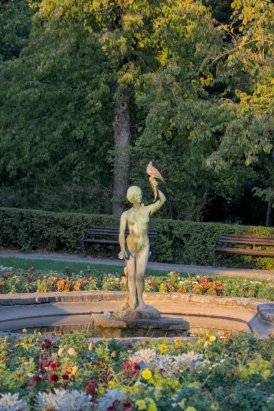 Escultura de una niña con una cornucopia, sobre la cual se posa un pájaro, en un parque de Novi Sad, Serbia.