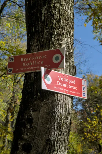 Putokaz na drvetu koji upućuje na "Brankovac Kobilica" i "Vodopad Dumbovac" na Fruškoj, u jesenjem svetlu.
