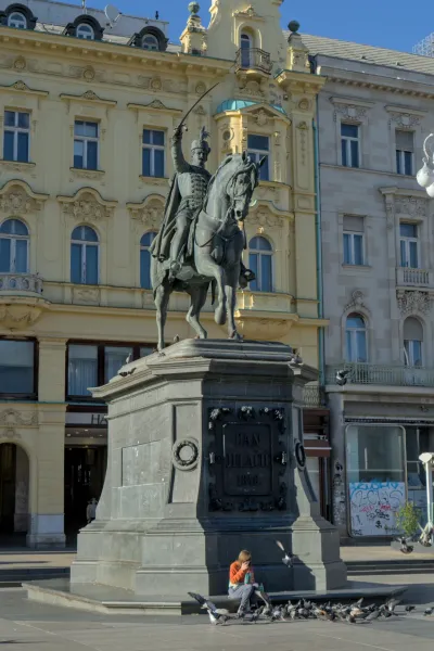 Il monumento equestre di Ban Jelačić a Zagabria, Croazia, con una persona che dà da mangiare ai piccioni.
