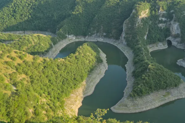Un río sinuoso bajo el sol poniente, rodeado de colinas verdes en Serbia.