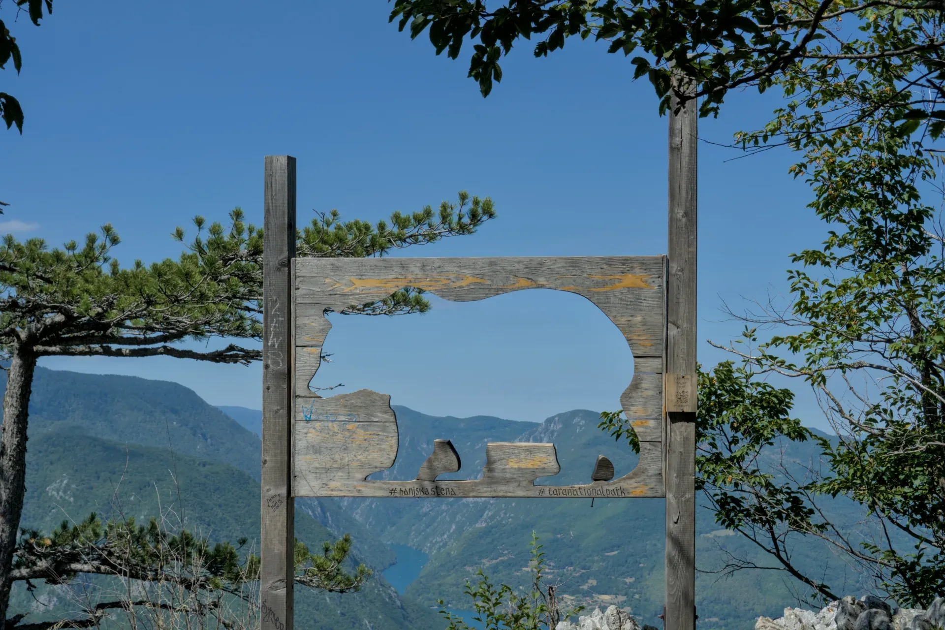 View through a bear-shaped wooden frame at the mountain landscape of Tara National Park, Serbia, from Banjska Stena viewpoint.