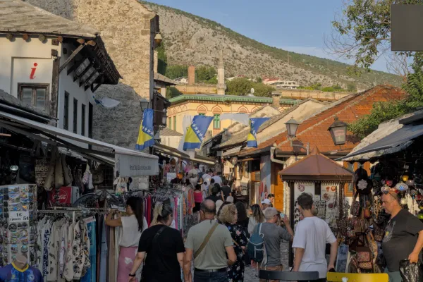 Evening light in Mostar's historic old town, featuring bustling streets and traditional architecture.