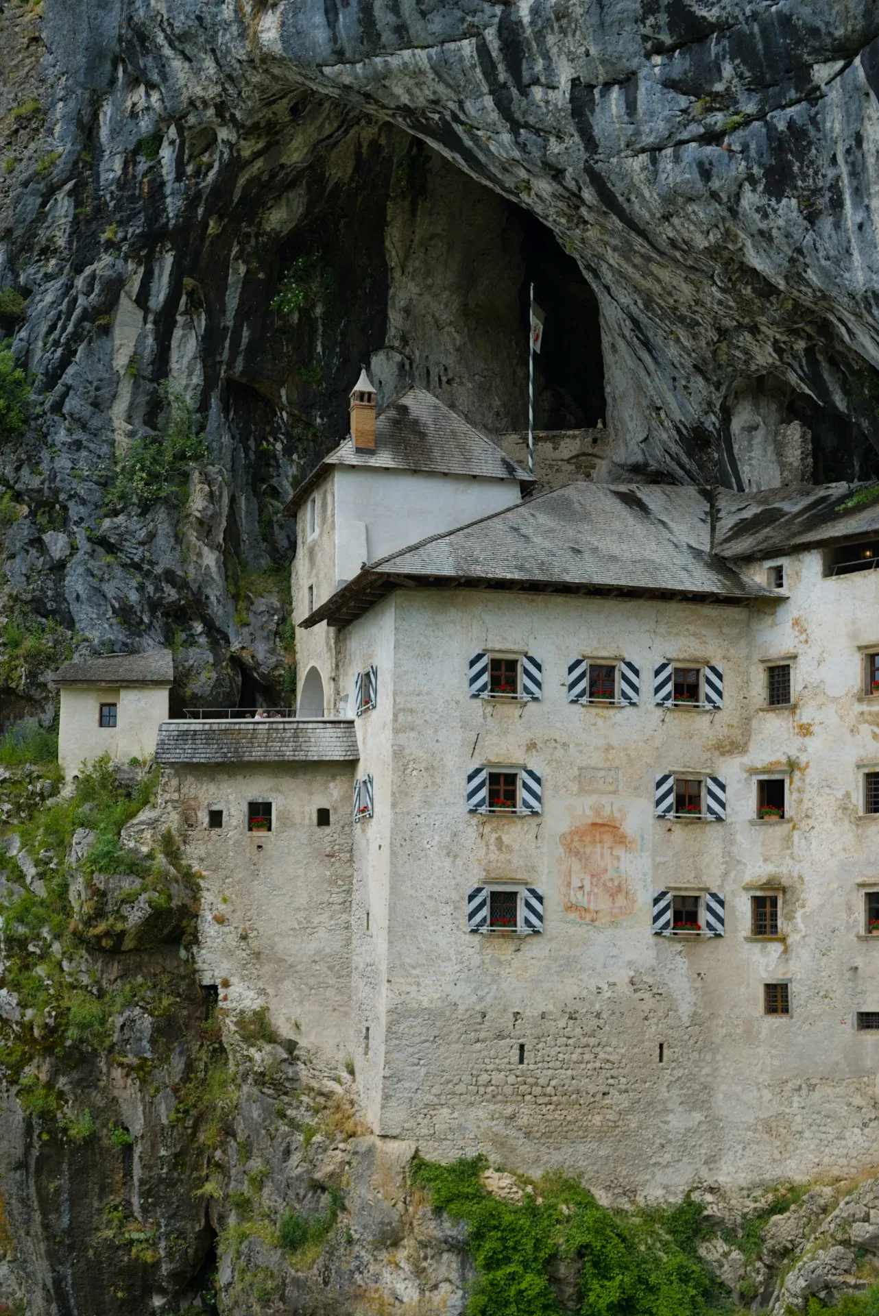 El старинный предъямский замок в скале, un antiguo castillo construido en un acantilado rocoso en Eslovenia, con arquitectura y piedra natural destacadas.