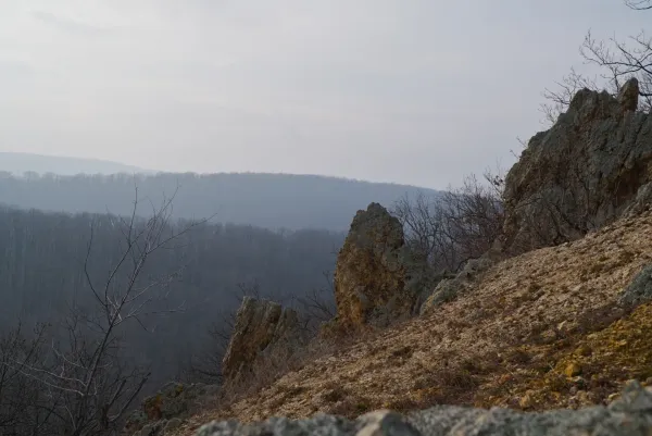 Die "Orlove Stene" auf Fruska Gora, Serbien, mit felsigem Gelände und bewaldeten Hügeln im Hintergrund.