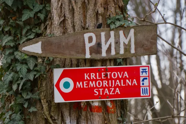 Drveni putokaz sa natpisom "Рим" i crvena tabla "Krletova Memorijalna Staza" na drvetu u Fruškoj Gori.