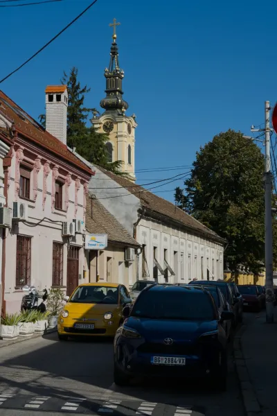 Photographie portrait d'une rue à Zemun, Belgrade, avec des bâtiments historiques et un clocher.