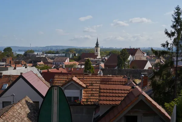 Panoramski pogled na zemunski kraj u Beogradu, Srbija, sa brojnim krovovima od crepova i crkvom u daljini.