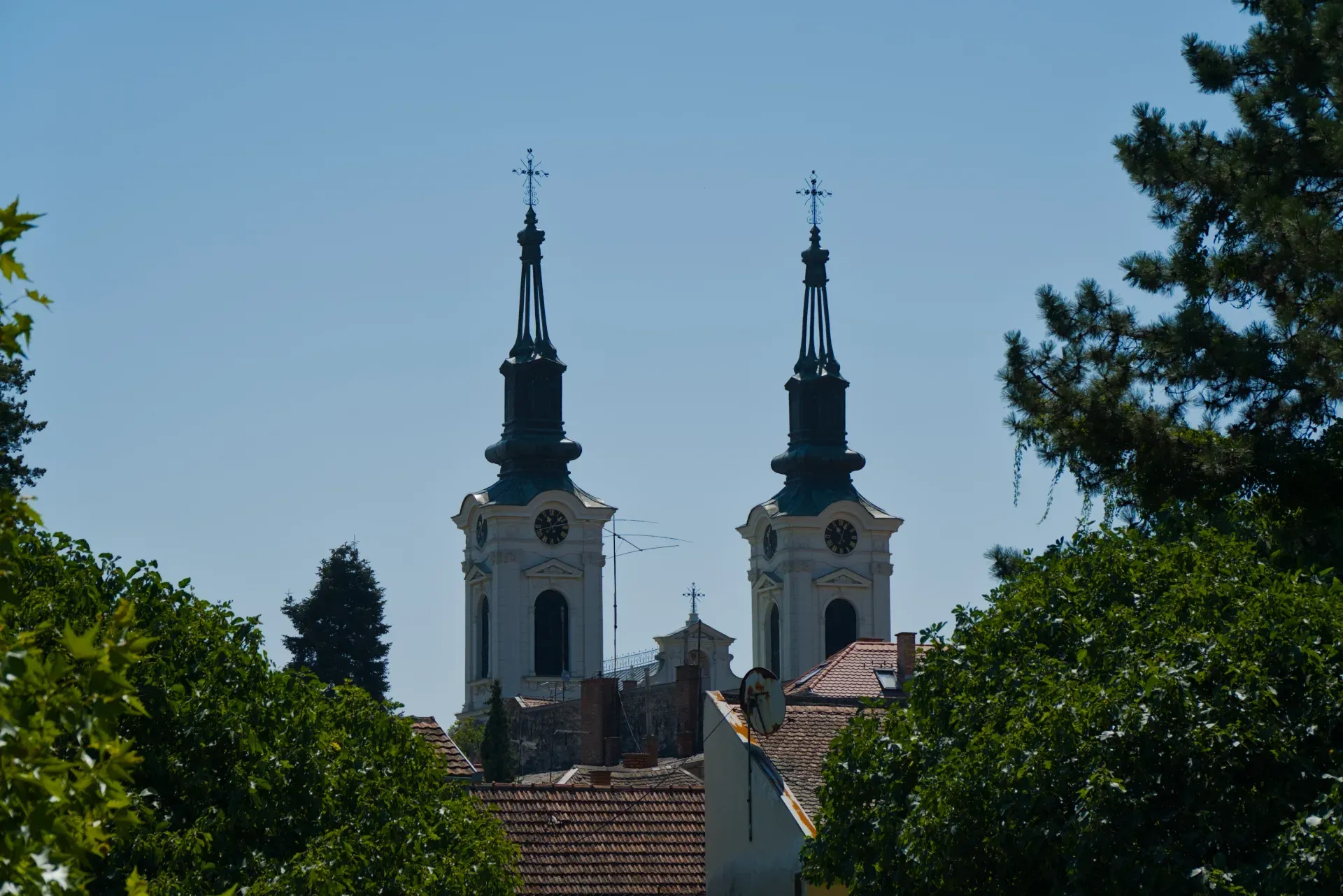 Dos torres campanario de la Iglesia de San Nicolás en Sremski Karlovci, Serbia, contra un cielo azul claro.