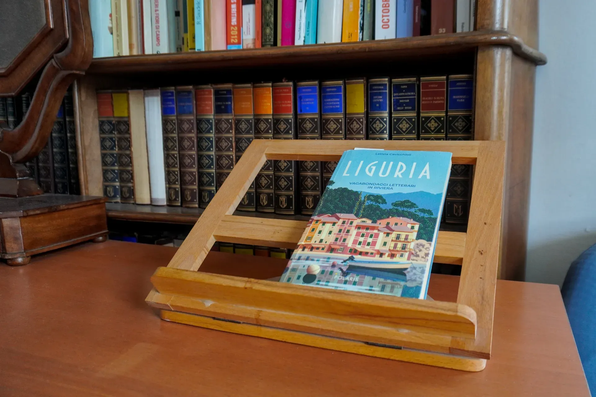 Knjiga pod nazivom 'Liguria' predstavljena je na drvenom štafelaju, postavljenom na sto ispred velike police sa starinskim knjigama. Korica knjige prikazuje slikovit pogled na ligurijsku arhitekturu i čamac.