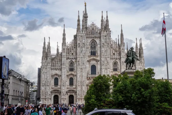 Una toma panorámica de la Piazza Duomo en Milán, Italia, con la icónica Catedral de Milán al fondo y mucha gente caminando por la plaza.
