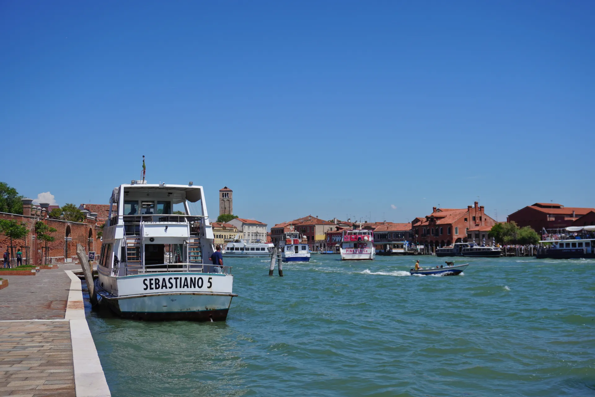 A view of a canal in Venice, Italy, with boats on the water and buildings along the shore.